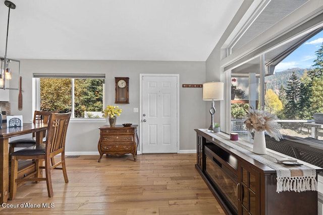 interior space with lofted ceiling and light hardwood / wood-style flooring