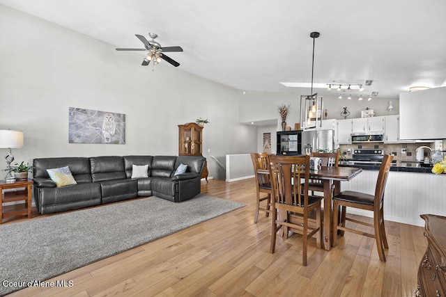 dining room with light wood-type flooring, ceiling fan, and sink