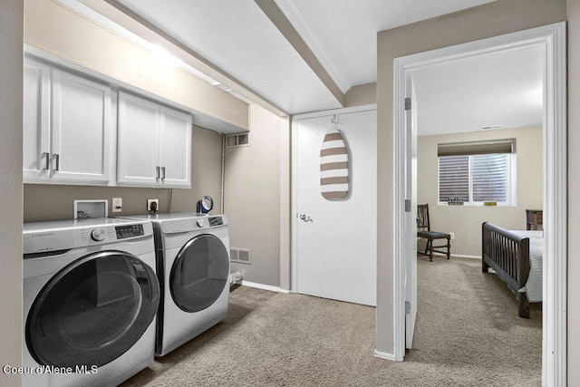 clothes washing area featuring light colored carpet, cabinets, independent washer and dryer, and ornamental molding