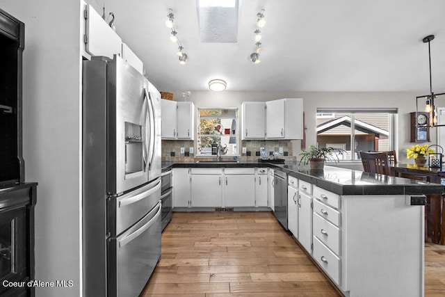 kitchen featuring stainless steel appliances, white cabinets, light hardwood / wood-style flooring, and sink