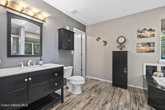 full bathroom featuring vanity, separate shower and tub, toilet, and hardwood / wood-style flooring