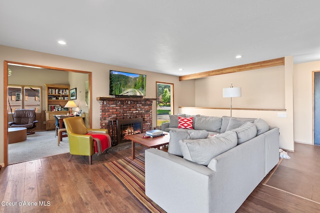 living room featuring a brick fireplace and hardwood / wood-style floors