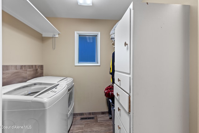 laundry area with separate washer and dryer and tile patterned floors