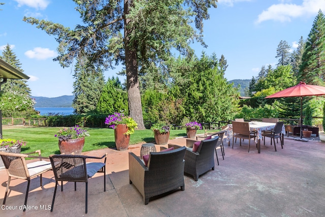 view of patio / terrace featuring a water and mountain view