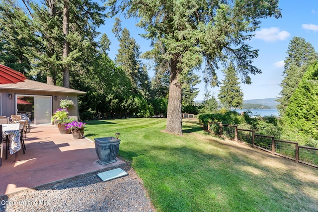 view of yard featuring a patio and a water view