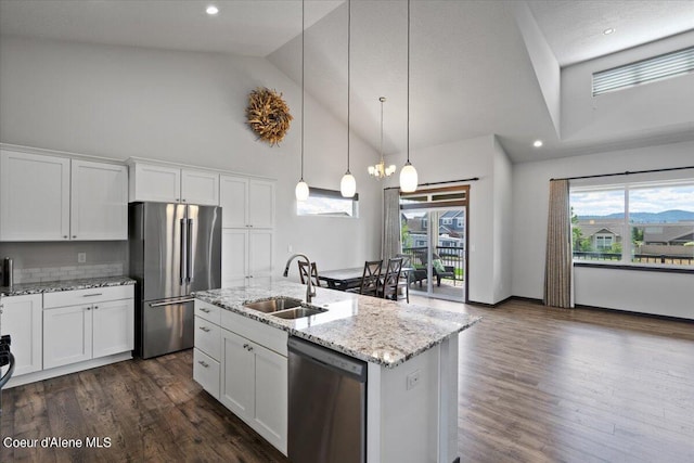 kitchen with sink, white cabinetry, decorative light fixtures, an island with sink, and stainless steel appliances