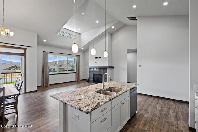 kitchen with sink, white cabinetry, decorative light fixtures, dishwasher, and an island with sink