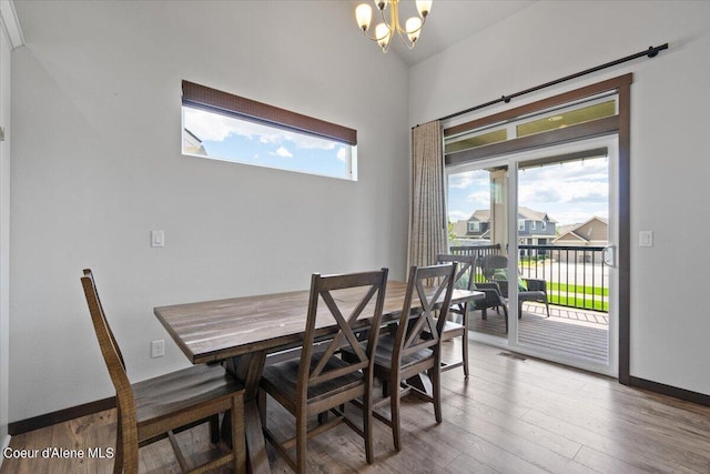 dining area with hardwood / wood-style flooring, a chandelier, and a healthy amount of sunlight