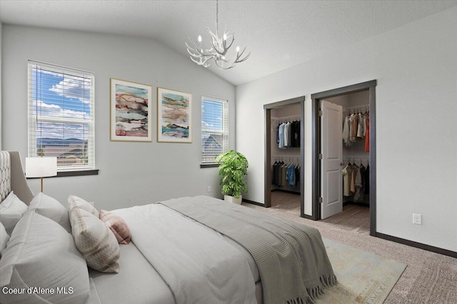 bedroom with light carpet, a walk in closet, vaulted ceiling, and an inviting chandelier