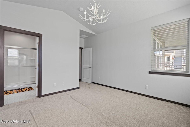 unfurnished bedroom featuring an inviting chandelier, vaulted ceiling, and light carpet