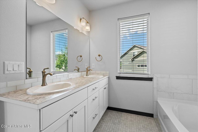 bathroom with vanity, a healthy amount of sunlight, and a bath