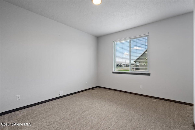 carpeted spare room featuring a textured ceiling