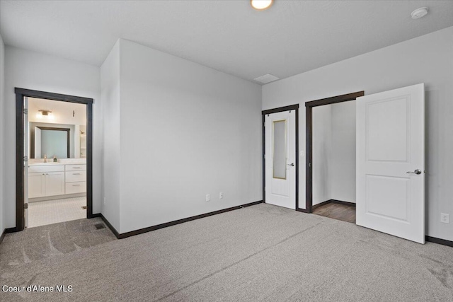 unfurnished bedroom featuring connected bathroom and dark carpet