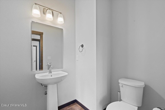 bathroom featuring wood-type flooring and toilet