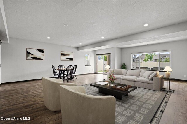 living room with hardwood / wood-style flooring, a wealth of natural light, and a textured ceiling