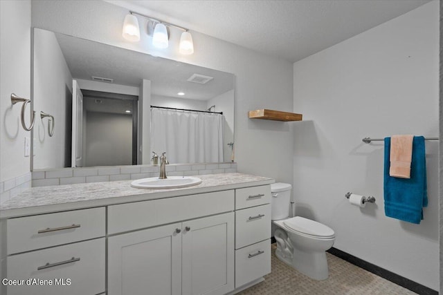 bathroom with a shower with curtain, vanity, a textured ceiling, and toilet