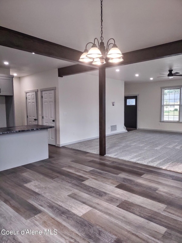 unfurnished living room with carpet flooring and ceiling fan with notable chandelier