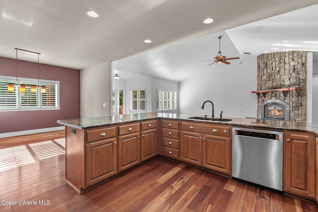 kitchen with sink, dark stone countertops, dark hardwood / wood-style flooring, dishwasher, and kitchen peninsula