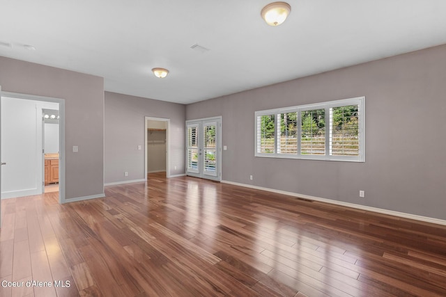 interior space featuring wood-type flooring, a wealth of natural light, and french doors