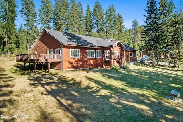 rear view of house featuring a deck and a lawn