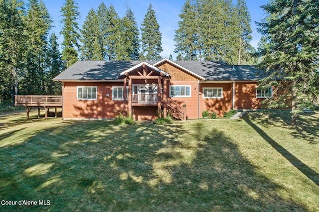 rear view of property with a deck and a lawn