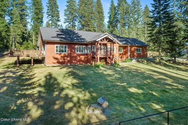 view of front of house with a wooden deck and a front yard