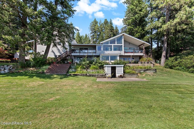 rear view of property featuring a yard and a patio area