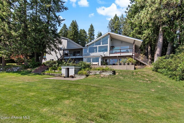 rear view of property featuring a deck and a yard