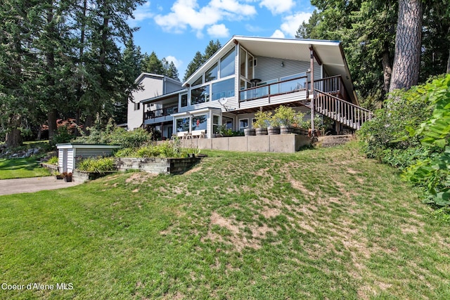 back of house featuring a yard and stairs