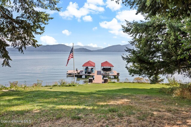 dock area featuring a water and mountain view and a yard