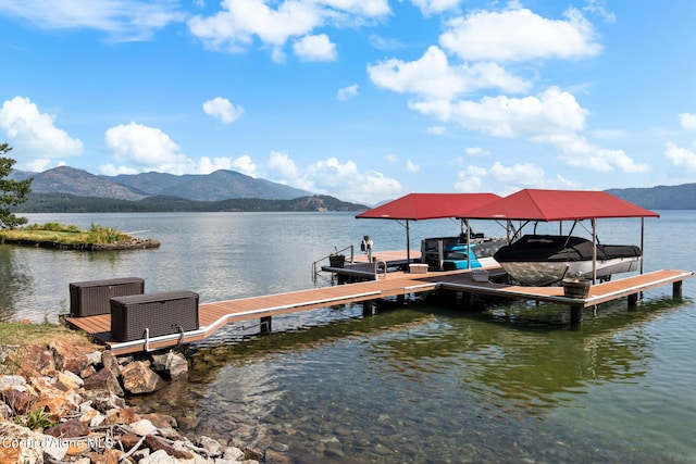 view of dock with a water and mountain view, boat lift, and central AC unit