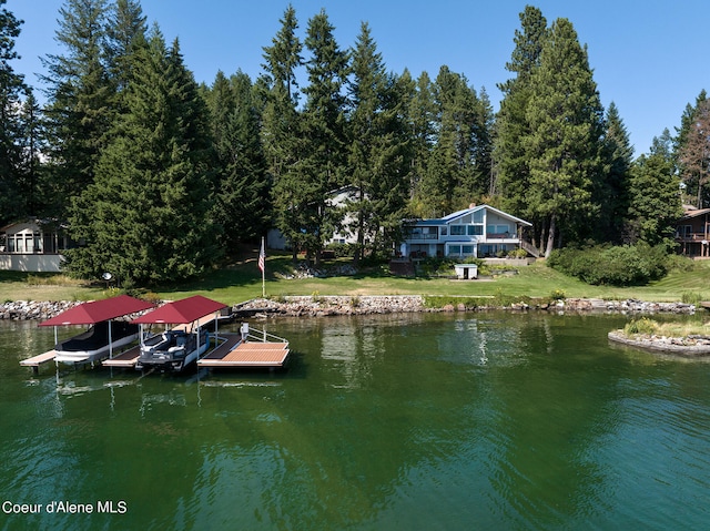 view of dock featuring boat lift, a lawn, and a water view