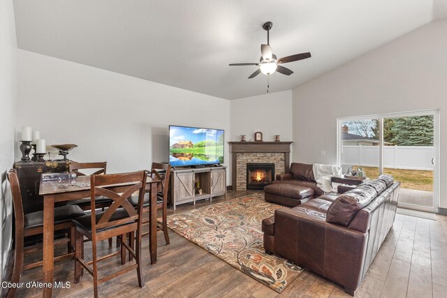 living room featuring hardwood / wood-style flooring, lofted ceiling, a fireplace, and ceiling fan