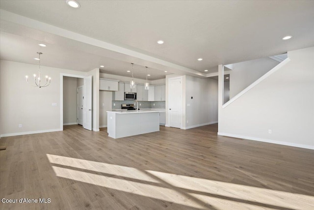 kitchen with white cabinetry, hanging light fixtures, a center island, and appliances with stainless steel finishes