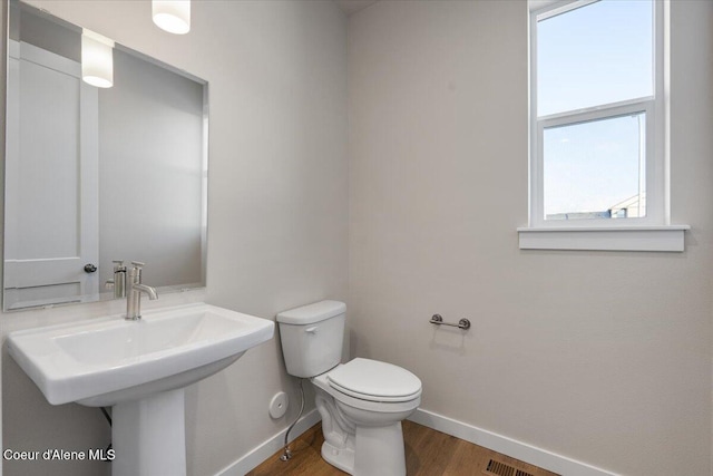 bathroom with hardwood / wood-style floors, sink, and toilet