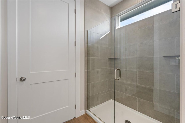 bathroom featuring a shower with shower door and hardwood / wood-style floors