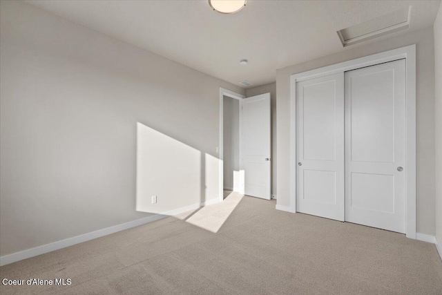 unfurnished bedroom featuring light colored carpet and a closet