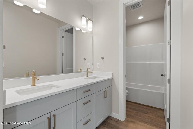 bathroom with hardwood / wood-style flooring, vanity, and toilet