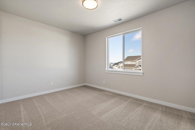 carpeted spare room with a textured ceiling