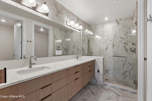 bathroom with marble finish floor, a sink, a marble finish shower, and double vanity