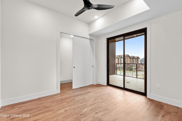 unfurnished bedroom featuring a ceiling fan, access to outside, baseboards, and light wood finished floors