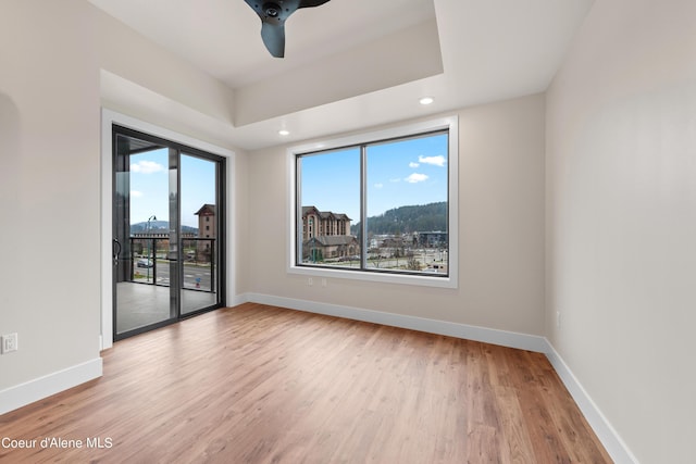 empty room with a ceiling fan, baseboards, wood finished floors, and recessed lighting