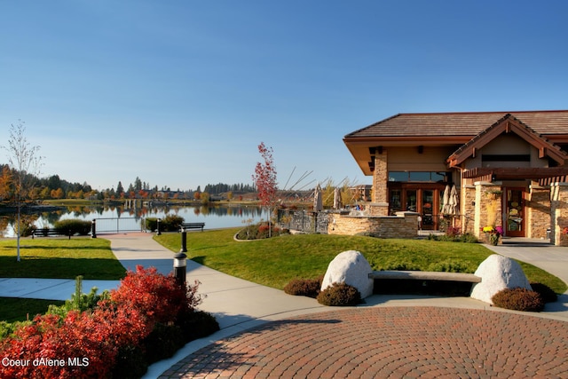 view of property's community featuring a water view and a lawn