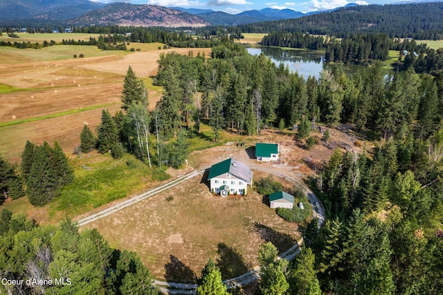 aerial view with a forest view, a water and mountain view, and a rural view