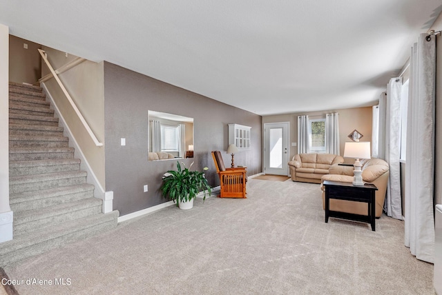 living area featuring light carpet, stairway, and baseboards