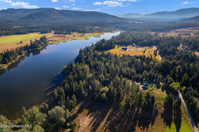 drone / aerial view featuring a water and mountain view