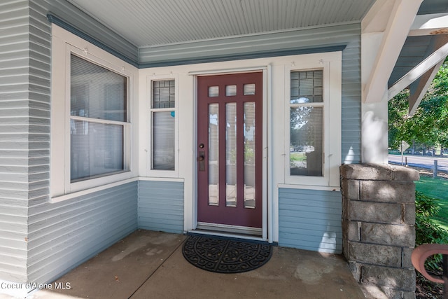 view of exterior entry featuring covered porch