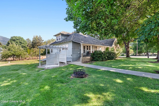 view of front facade with a pergola, a front lawn, and a fire pit