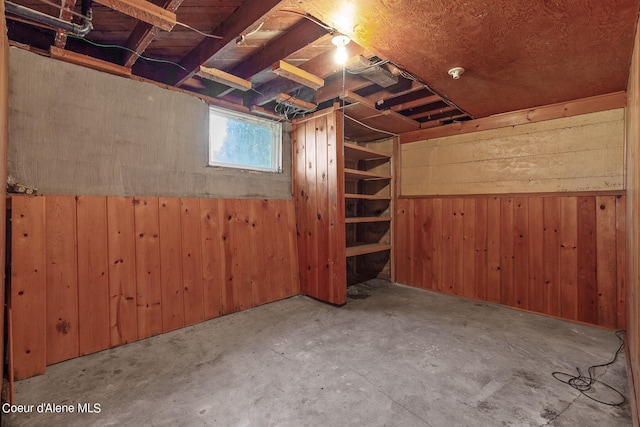 basement featuring wooden walls