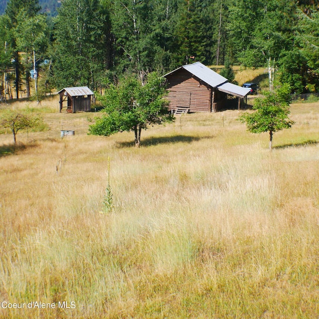 view of yard with an outbuilding and a rural view